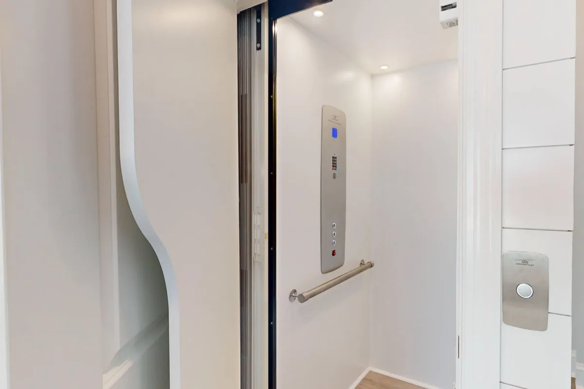 This image features the interior of an elevator, focusing on the control panel, handrail, and ambient lighting. The scene emphasizes ease of access to different floors, crucial for guests of all ages and mobility levels.